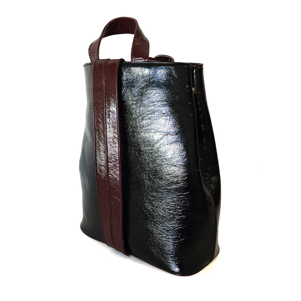 Mochila Backpack de piel para mujer de charol negro con cinta artesanal de chaquira. Vista 3/4